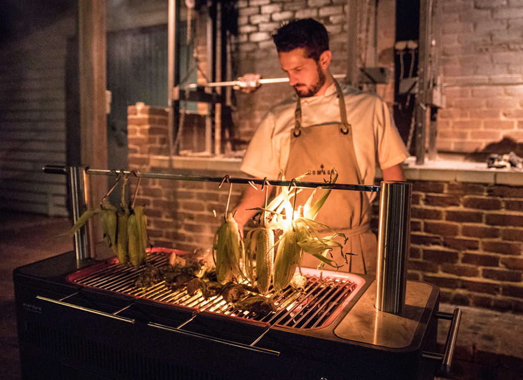 Cooking corn over coals at Homage